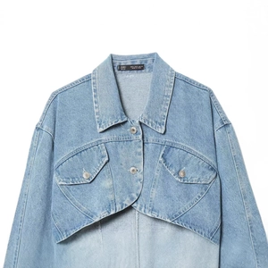 Cropped view of a light blue washed denim jacket with chest pockets on white background