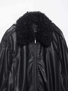 Détail d'un blouson aviateur en similicuir noir avec un col épais en fausse fourrure et zip