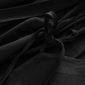 Macro detail of the black wrap dress waist tie and soft textured fabric layers