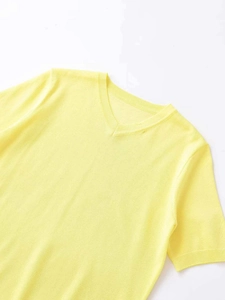 Detailed close-up of yellow V-neck knitted top showing fine ribbing and breathable fabric texture
