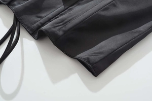 Dettaglio del tessuto satinato nero con cuciture fini e coulisse laterale regolabile