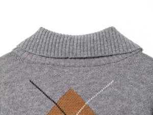 Detailaufnahme des grauen Argyle-Strickpullovers mit Rippkragen und Rautenmuster-Textur