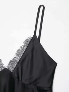 Detailed view of black satin slip dress with delicate eyelash lace trim at the V-neckline