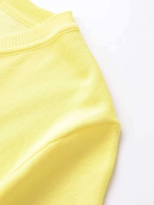 Detailed close-up showing the soft knit texture and collar stitching of yellow top