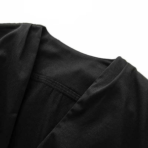 Detail view of black V-neck dress fabric with pleated texture and refined stitching
