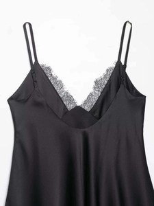 Detail of V-neckline with delicate eyelash lace on a black satin slip dress