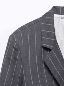 Detailansicht des dunkelgrauen Nadelstreifen-Blazers mit Stoffstruktur und Kragennaht