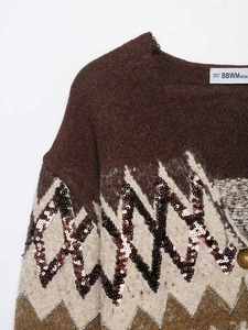 Detail of V-neck brown jacquard knit sweater with sequins and textured knit fabric