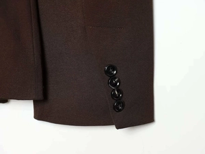Detail of dark brown twill blazer sleeve with four classic black buttons on cuff