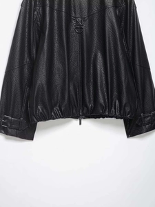 Détail du bomber en similicuir avec fermeture éclair et sangles de poignet réglables