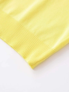 Close-up of bright yellow knit top showing ribbed cuff details and soft fabric texture