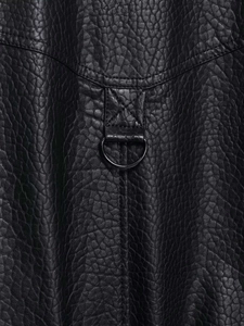 Vue macro du cuir grainé noir avec coutures renforcées et détail de l'anneau en D métallique