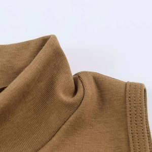 Dettaglio del top senza maniche in maglia marrone con collo alto e cuciture di alta qualità