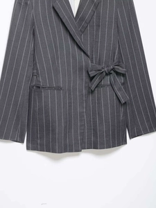 Detail eines dunkelgrauen Nadelstreifen-Blazers mit modischer Seitenschleife