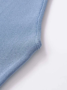 Dettaglio del gilet in maglia azzurro che mostra la trama a coste e le cuciture fini
