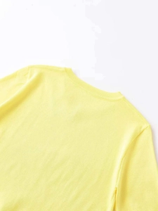 Close-up of yellow knit top featuring a V-neck ribbed edge and fine texture details