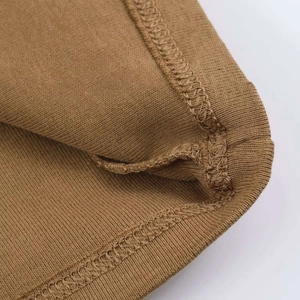 Vista macro delle cuciture overlock sull'orlo di un tessuto a costine marrone