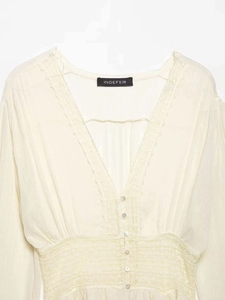 Close-up of elegant V-neckline with delicate lace trim and pearl buttons on chiffon blouse