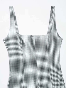 Detail of black and white gingham dress featuring square neckline and side zipper closure