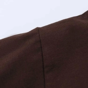 Gros plan des coutures précises et de la texture de la robe plissée marron chocolat