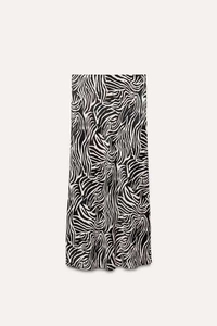 Detailed view of the elegant black and white zebra print on a smooth satin midi skirt