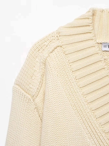 Close-up detail of beige ribbed V-neckline and high-quality knit texture of the cardigan