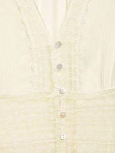 Detail of cream chiffon blouse featuring crochet lace inserts and pearlescent buttons