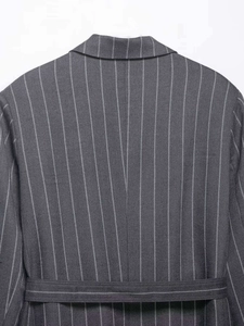 Detailansicht eines grauen Nadelstreifen-Blazers mit Taillengürtel und Wollstruktur