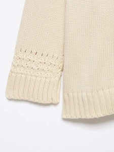 Detail of hollow-out pattern and ribbed cuffs on a cream chunky knit cardigan