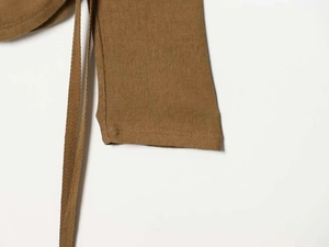 Détail du tricot côtelé marron avec cordon à chevrons et coutures de précision