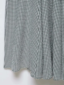 Detail shot of black and white gingham woven fabric with textured pleats and drape