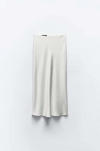 Detailed close-up of cream satin midi skirt showing smooth silk texture and clean waistline