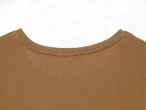 Détail du t-shirt en tricot marron montrant le col rond à double couture et la texture du tissu