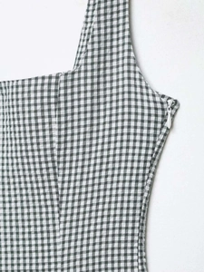 Detail of gingham dress showing side invisible zipper and square neck strap texture