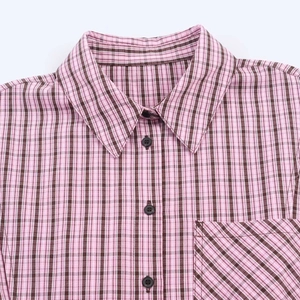 Detail of pink and black plaid shirt featuring a button-down collar and chest pocket