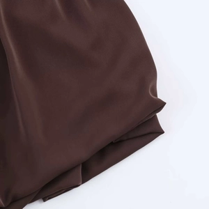 Detailed close-up of dark brown satin fabric texture showing smooth silk-like finish