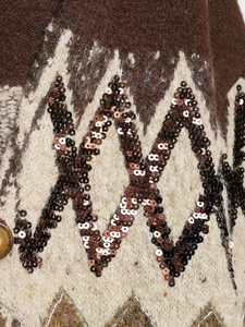 Macro detail of vintage jacquard knitwear with bronze sequins and geometric embroidery
