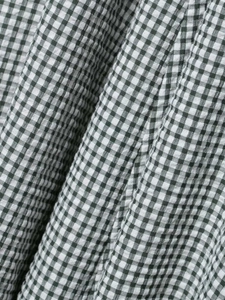 Close-up of green and white gingham seersucker fabric with textured puckered surface