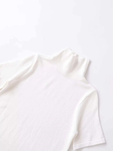 Detailed view of white mock neck short sleeve knit top with fine ribbed texture