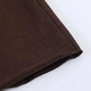 Détail de la robe en maille marron chocolat montrant la texture fine et l'ourlet