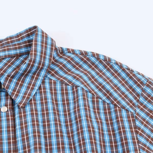Detail of blue and brown plaid dress shoulder seam with high quality stitching