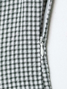 Detail of green gingham maxi dress showing the high-quality white invisible zipper