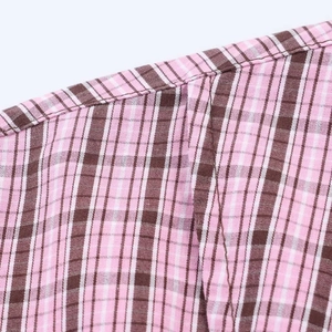 Detail shot of pink and black plaid fabric showing fine stitching and plain weave texture