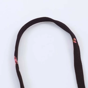 Détail des fines bretelles sur une robe midi fleurie noire avec couture de qualité
