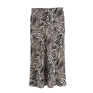 Detail shot of midi satin skirt featuring high-waisted cut and black zebra animal print