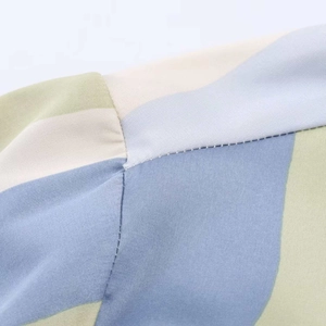 Detailed close-up of neat stitching and fiber texture on striped satin shirt fabric