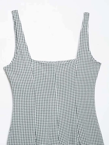 Detail of square neckline and wide straps on a black and white gingham dress