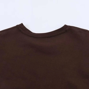 Détail du col rond de la robe marron plissée montrant les coutures et la texture du tissu