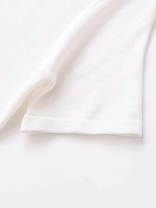 Close-up of white knit fabric texture and smooth hem finishing on short sleeve top