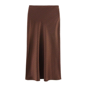 Detail of dark brown satin midi skirt featuring black polka dots and smooth texture